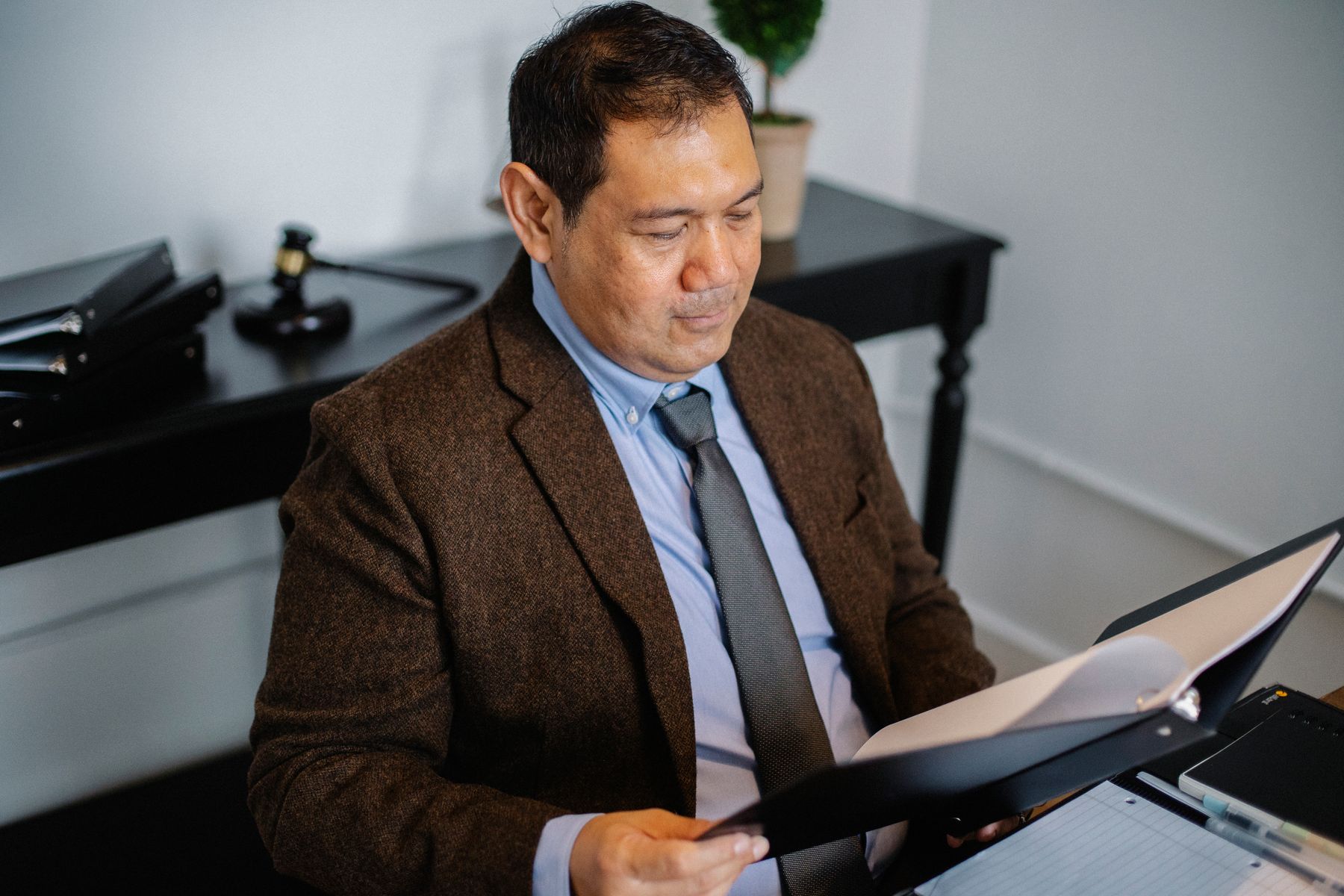 Un homme examine un dossier papier à son bureau